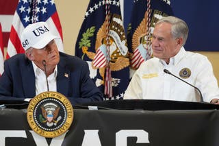President Donald Trump, left, speaks as Texas Gov. Greg Abbott listens during a roundtable discussion with first responders and local officials at Hill Country Youth Event Center in Kerrville, Texas, during a tour to observe flood damage